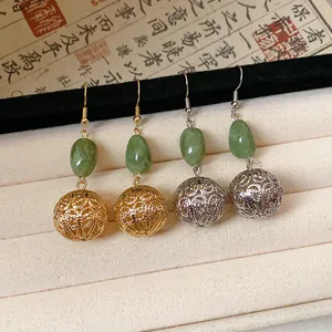 Detailed view of New Chinese style earrings featuring green resin and hollow metal filigree