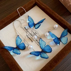 Detailed view of exquisite blue butterfly wing earrings with elegant white pearls