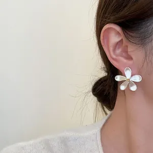 Elegant silver flower stud earring shown on a female model's ear, Korean minimalist style