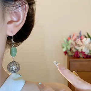 Detailed view of Neo-Chinese vintage resin earrings featuring silver hollow sphere drops