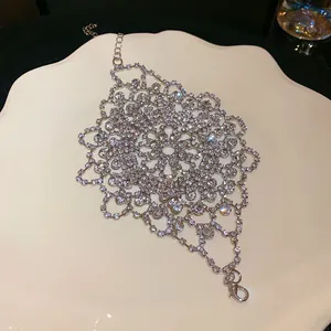 Close-up view of an intricate silver floral hand bracelet with sparkling rhinestones