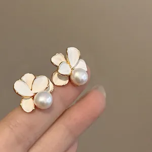 Close-up detail of elegant 18k gold plated flower stud earrings with central pearls
