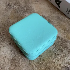 Close-up of portable cyan leather jewelry box with zipper for earrings and necklaces