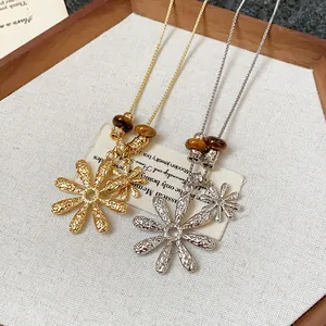 Detailed view of vintage tiger eye beaded necklace with hammered metal flower pendants