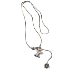 Elegant silver-toned horse pendant necklace featuring zirconia accents and a delicate flower charm.
