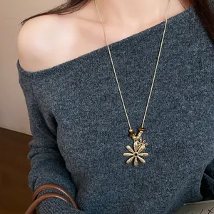 Detailed view of an elegant tiger eye bead necklace with a gold flower pendant