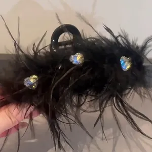 Elegant black feather hair claw clip adorned with heart-shaped iridescent rhinestones