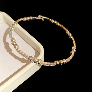 Vista detallada del brazalete abierto plateado con strass brillantes y cuentas
