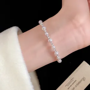 Detalle de una pulsera de perlas minimalista de estilo retro francés con pedrería