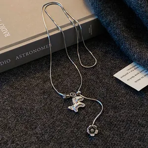 Detailed view of silver horse necklace with zirconia and flower pendant