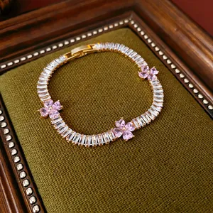 Vintage-inspired gold bracelet with sparkling clear zircons and pink flower-shaped gems