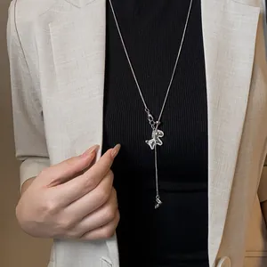 Close-up of silver horse pendant necklace with zircons on elegant blazer outfit