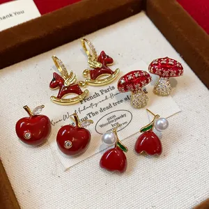 Exquisite detail of red oil-drop enamel earring set featuring apple and horse designs