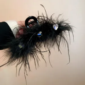 Macro view of black feather hair claw clip with sparkly heart rhinestones