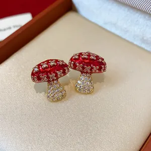 Detailed view of exquisite red enamel and zircon mushroom stud earrings on velvet