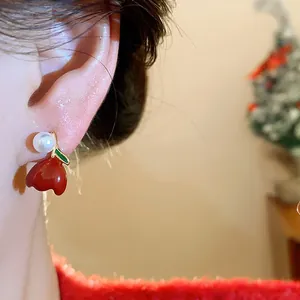 Close-up macro detail of red enamel tulip stud earrings with white pearl and gold accents.