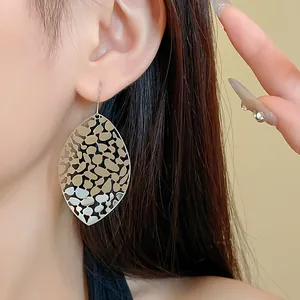 Detailed view of silver hollow-out leaf drop earrings with geometric leopard pattern