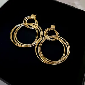 Vue détaillée de boucles d'oreilles créoles dorées vintage sur boîte en velours noir