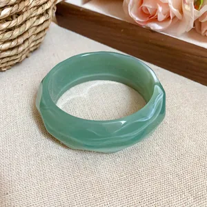 Wavy faceted pale green acrylic bangle bracelet with a translucent jade-like finish