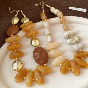 Detail of vintage Maillard brown resin necklace with irregular drop beads and gold accents.