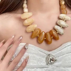 Detailed shot of an irregular teardrop resin bead necklace in warm vintage Maillard tones