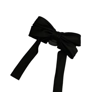 Elegant black satin bow hair claw clip for vintage style buns and chic hairstyles.