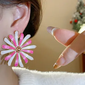 Detailed close-up shot of elegant pink and white oil drip flower stud earring on ear
