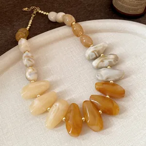 Close-up of irregular water-drop beads in Maillard amber and cream marbling