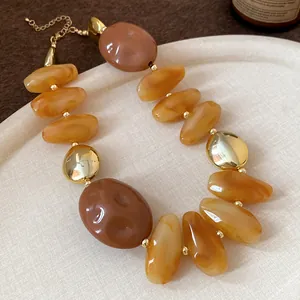 Macro detail of retro Maillard style amber resin necklace with gold accent beads