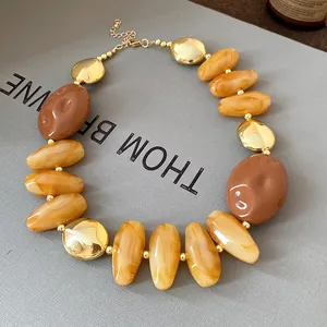 Close-up detail showing the glossy texture of a retro irregular amber and gold bead necklace