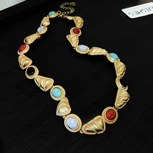 Gros plan d'un collier vintage de style royal avec maillons dorés et pierres colorées