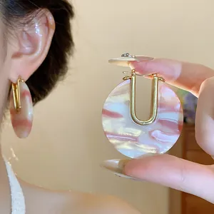 Close-up detail of vintage pink marbled acetate U-shaped earrings with 18k gold plating