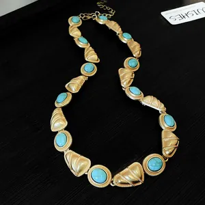 Détail d'un collier de style royal vintage avec des pierres turquoises sur fond noir