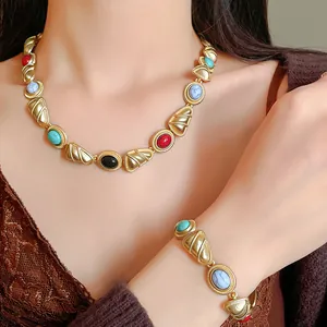 Vue détaillée du collier et du bracelet de style vintage avec pierres colorées et fini doré.