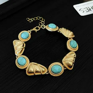 Détail macro du bracelet de style palais vintage avec maillons dorés et pierres turquoise