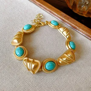 Vue macro d'un bracelet de style palais vintage avec des pierres turquoise et de l'or