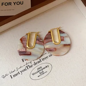 Close-up detail of 18k gold-plated acetate U-shaped hoop earrings with retro marble pattern