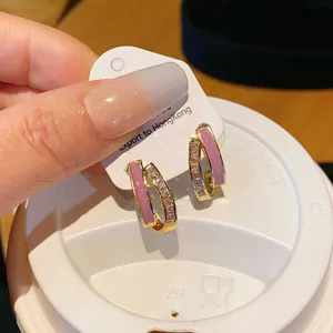 Detail view of gold-plated hoop earrings with pink enamel and sparkling zircons