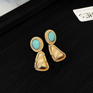 Gros plan de boucles d'oreilles vintage en or avec pierres turquoise pour femme