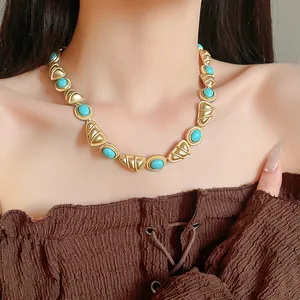 Gros plan d'un collier de style palais vintage avec des pierres turquoise et de l'or.