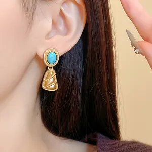 Vue détaillée d'une boucle d'oreille géométrique de style vintage avec turquoise