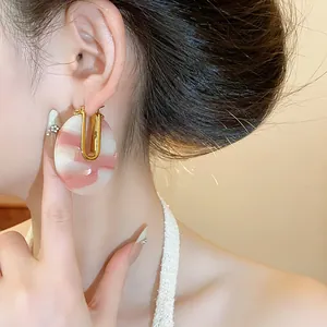 Close-up view of retro pink marbled acetate U-shaped earring worn by an Asian model