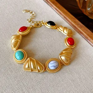 Gros plan d'un bracelet doré de style palais vintage orné de pierres colorées