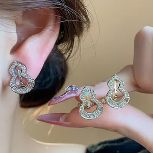 Detailed close-up view of 18k gold plated gourd-shaped clip earrings with zircons