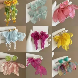 Collection de boucles d'oreilles fleurs en tulle avec cœurs en résine et pompons.