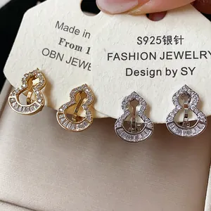 Macro detail of CZ paved gourd-shaped ear clips in gold and silver plating