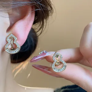 Close-up detail of 18k gold plated gourd-shaped ear clips encrusted with zircons.