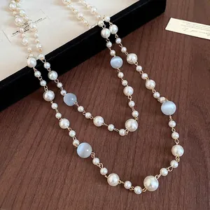 Elegante französische Retro-Lagenkette mit Perlen und Katzenaugensteinen auf Holz
