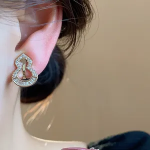 Close-up of 18k gold-plated gourd clip-on earring with pavé zircon detail on ear.