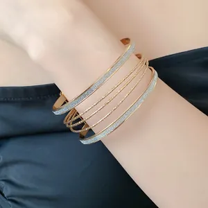 Elegant close-up showing multilayered rose gold and glittery silver bangles on a female wrist